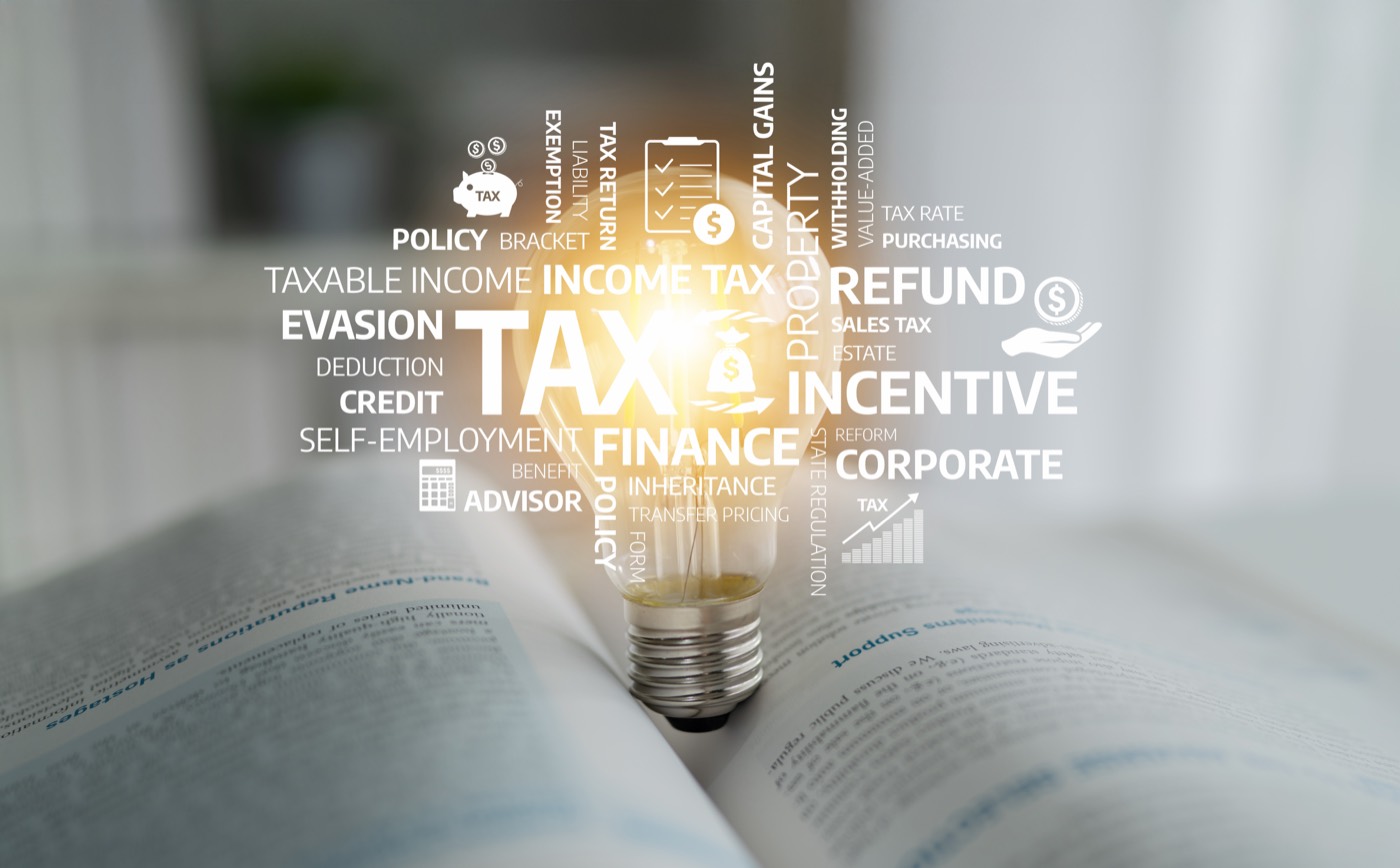 Bec luminos așezat pe o carte deschisă, înconjurat de termeni din domeniul fiscal